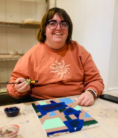 Micah working on one of her paintings at Lightspire studio